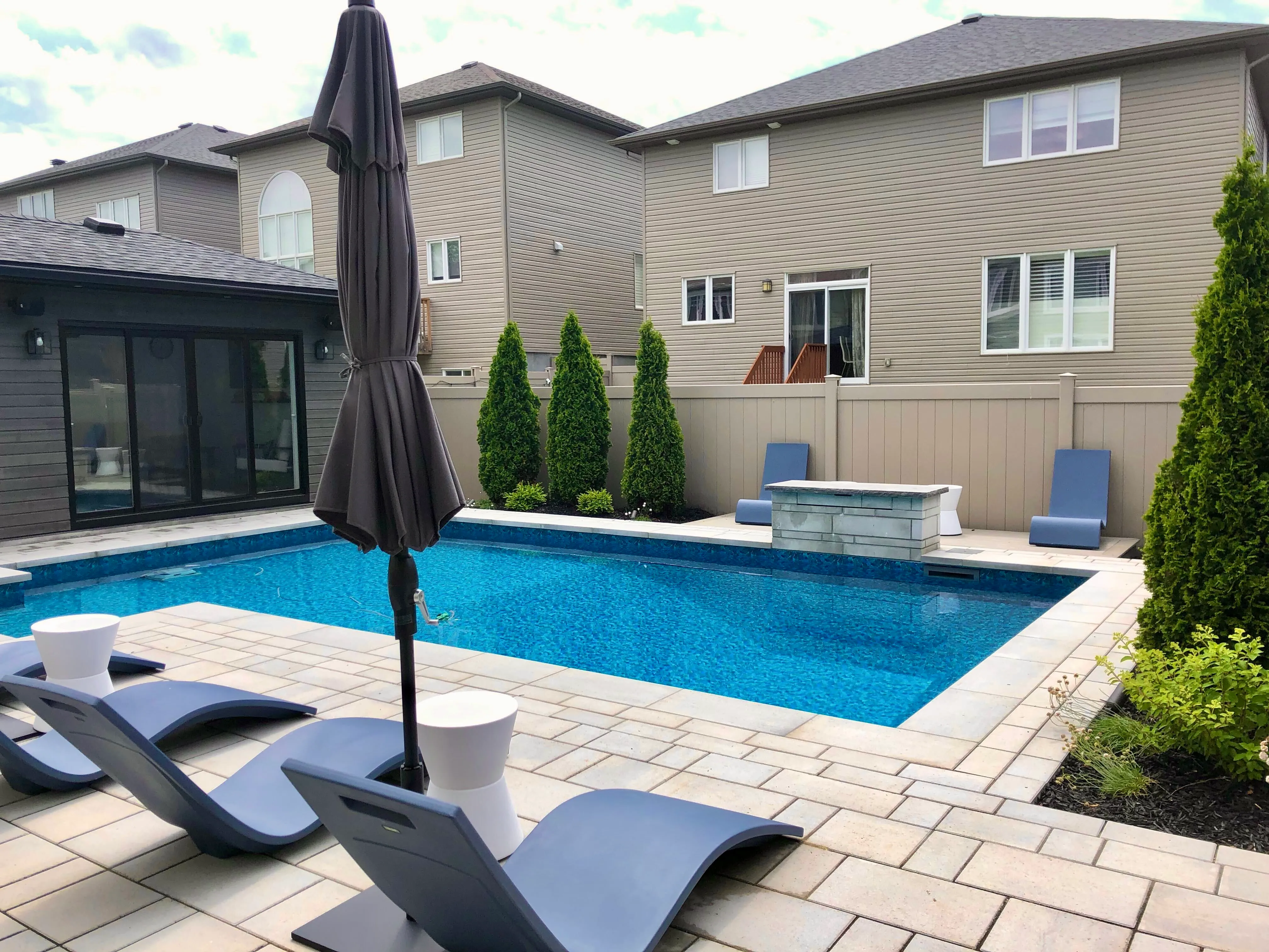 Blue rectangular inground pool with broad stone coping